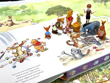 Illustrated book with small figurines of cartoon characters on a garden scene