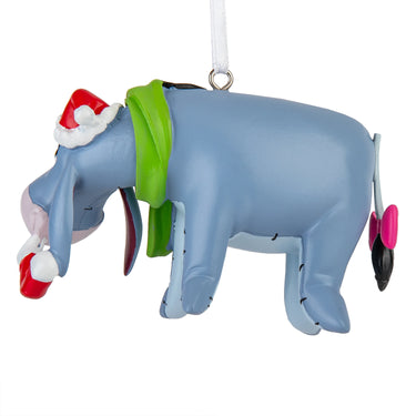 Decorative elephant ornament with a Santa hat and green scarf on a white background