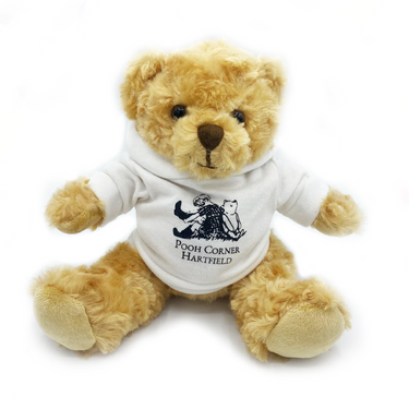 A plush teddy bear with a white hoodie featuring the Pooh Corner logo.