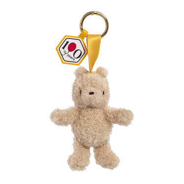 Winnie the Pooh keychain with a gold ring and 100th anniversary tag on a white background