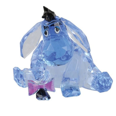 A blue acrylic figurine of Eeyore from Winnie the Pooh with a pink bow tie, sitting in a gift box.