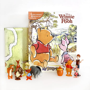 A Winnie the Pooh themed Busy Book with colorful illustrations, a playmat, and several figurines of characters including Winnie the Pooh and Piglet.