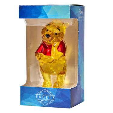 Yellow bear figurine with a red shirt in a blue and white box packaging, featuring the Facets Collection logo.