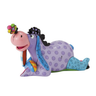 A figurine of Eeyore from Disney's Winnie the Pooh, depicted in a colorful design with lavender and blue colors and polka dots, lying down with a butterfly on his nose.