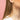 Gold Winnie the Pooh earrings worn by a person with a pink background