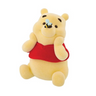 A flocked figurine of Winnie the Pooh wearing a red outfit, sitting and holding a bumble bee.