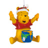 Christmas ornament of a yellow bear in a Santa hat with a blue bucket on a white background