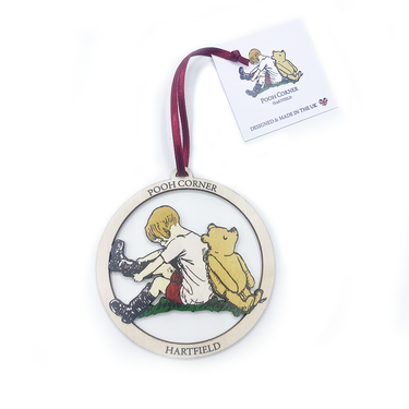 Decorative hanging with a design of a child and a bear, branded 'Pooh Corner', on a white background.