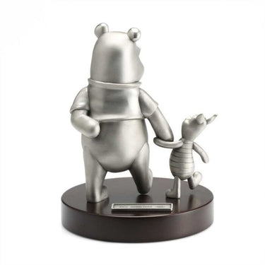 Metallic sculpture of a bear and a mouse on a wooden base against a white background