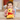 Child holding a plush Winnie the Pooh toy on a carpeted floor.