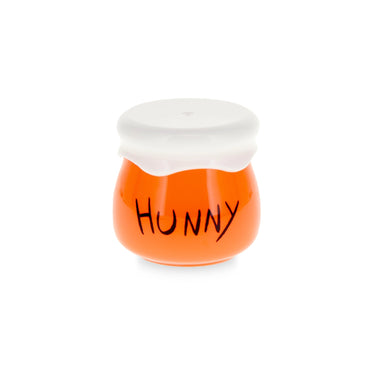An orange ceramic honey jar figurine with a white lid and the word 'HUNNY' written on the front in black script, set against a plain white background.