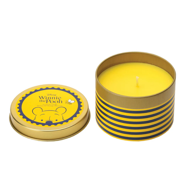 Yellow candle in a striped tin with a Winnie the Pooh lid on a white background