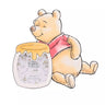 Winnie the Pooh holding a jar of honey with a photo frame in the background