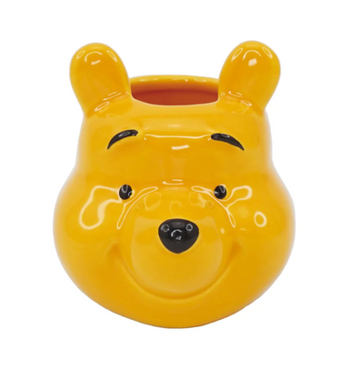 A ceramic mini pot shaped like Winnie the Pooh bear, primarily yellow in color with facial features and a smile depicted.